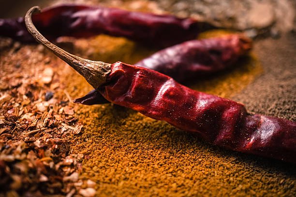 red chili flakes, dry red chilispices and curry powder concept background